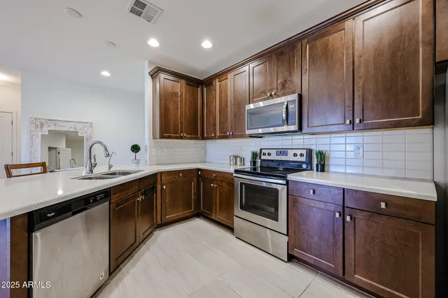 a kitchen with stainless steel appliances granite countertop wooden cabinets a sink and a stove