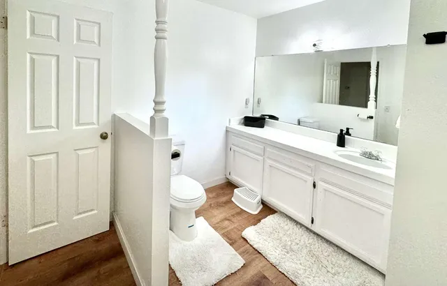 a bathroom with a double vanity sink mirror and toilet