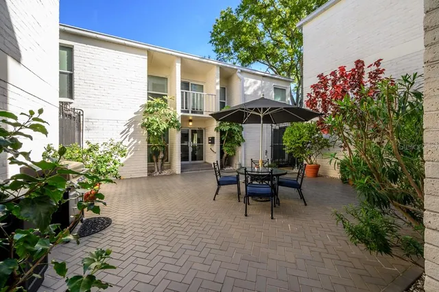 a view of a patio with table and chairs under an umbrella