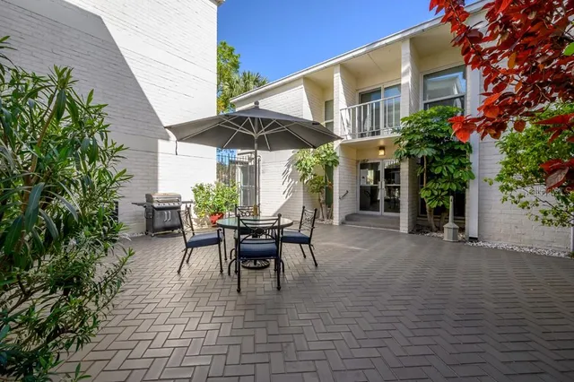 a view of a patio with table and chairs and potted plants
