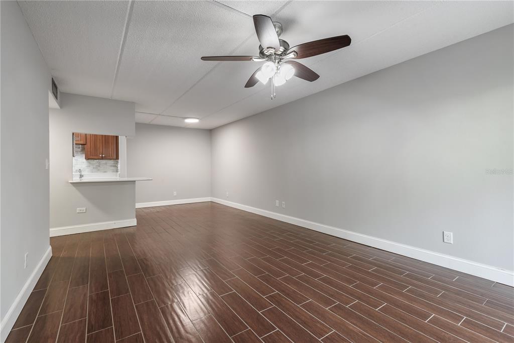 3325 Bayshore Boulevard, Unit A17 Tampa, FL 33629 - Photo 6 of 31 an empty room with wooden floor chandelier fan and windows