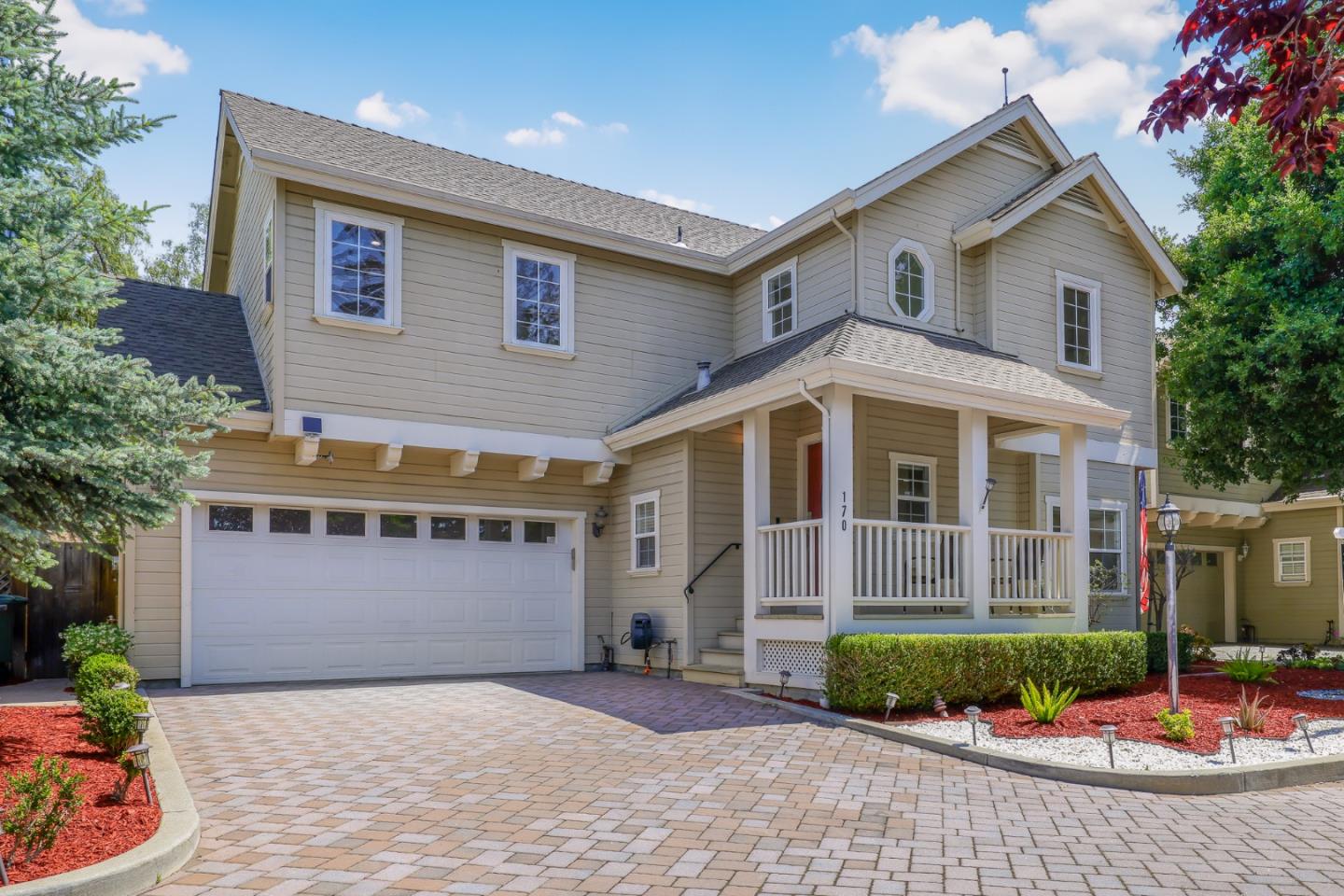 a front view of a house with garage and plants