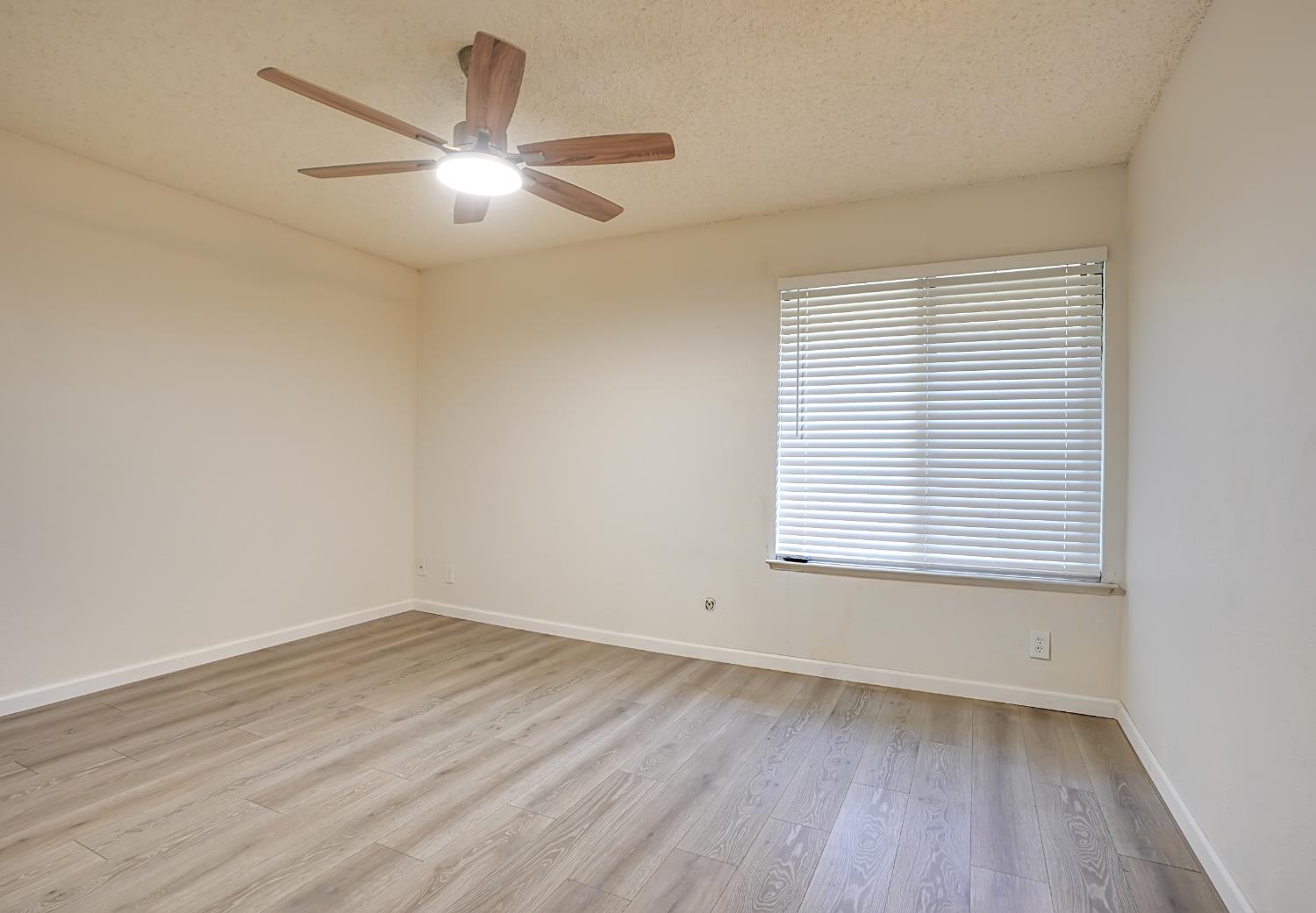 6724 Plymouth Road, Unit 88 Stockton, CA 95207 - Photo 11 of 21 an empty room with wooden floor and windows