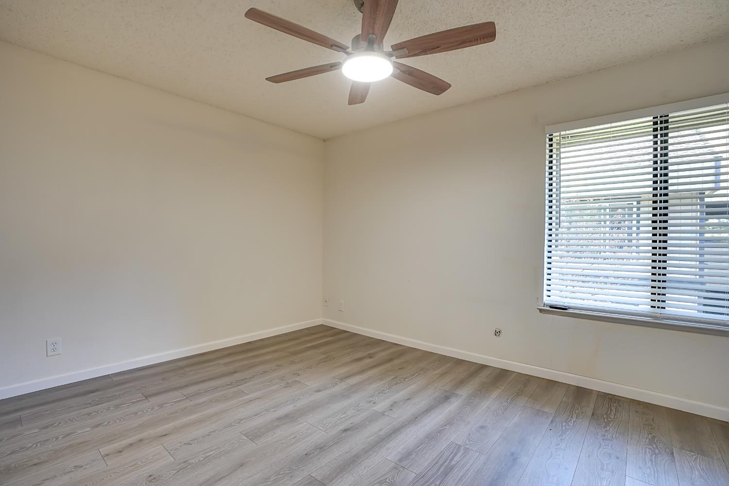 6724 Plymouth Road, Unit 88 Stockton, CA 95207 - Photo 12 of 21 wooden floor in an empty room with a window