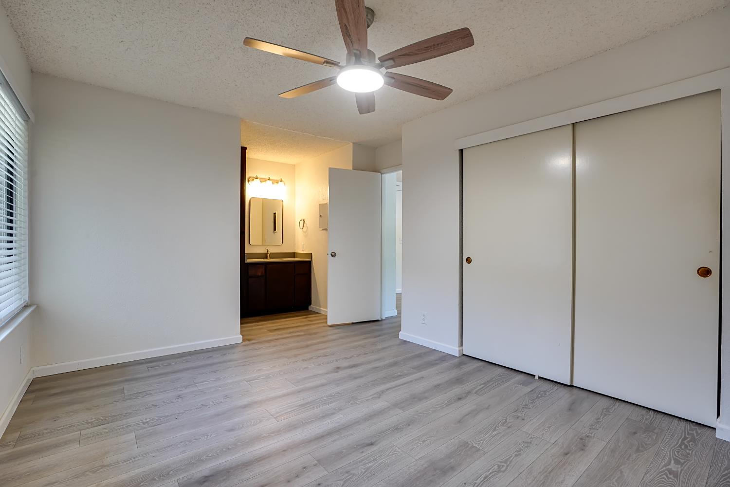 6724 Plymouth Road, Unit 88 Stockton, CA 95207 - Photo 13 of 21 an empty room with wooden floor and a ceiling fan