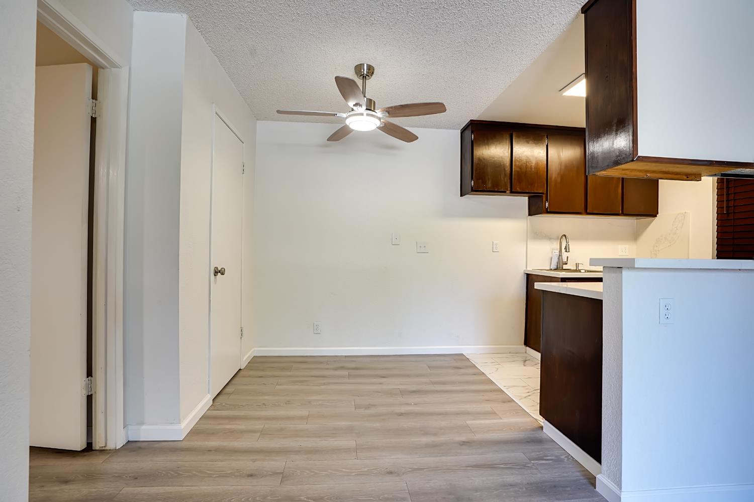 6724 Plymouth Road, Unit 88 Stockton, CA 95207 - Photo 7 of 21 a view of an empty room with wooden floor and a ceiling fan