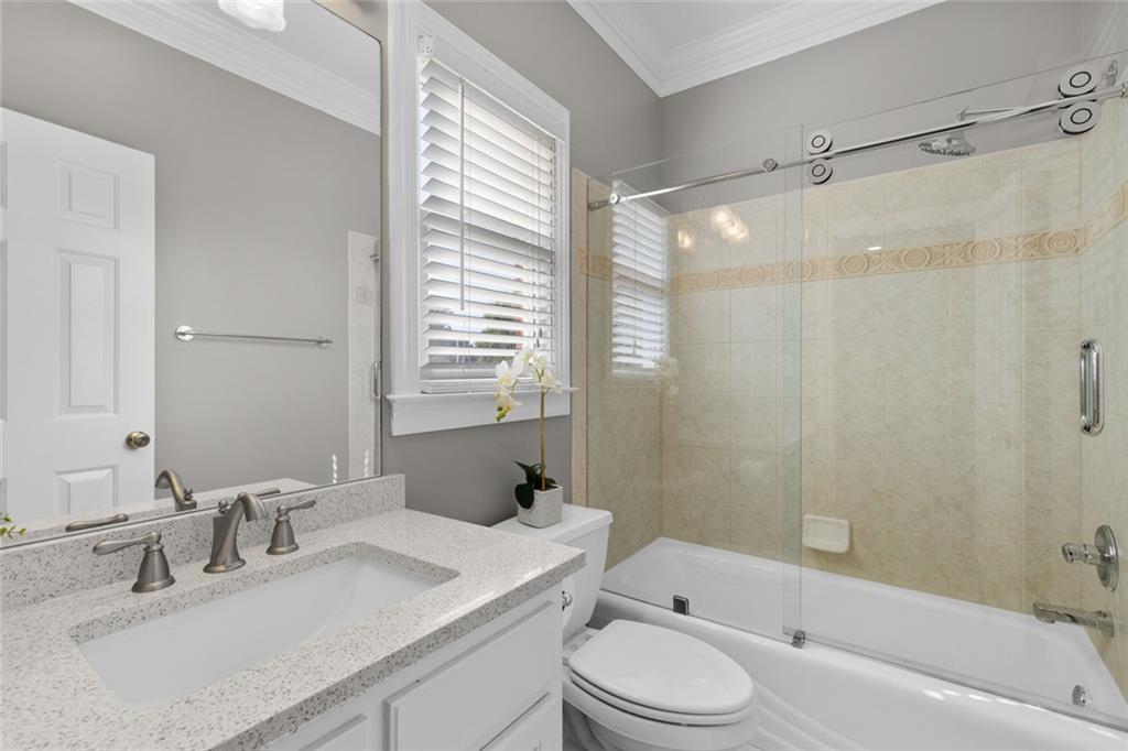 1225 Mobile Way Grayson, GA 30017 - Photo 22 of 51 a bathroom with a granite countertop sink toilet a large mirror a bathtub and shower