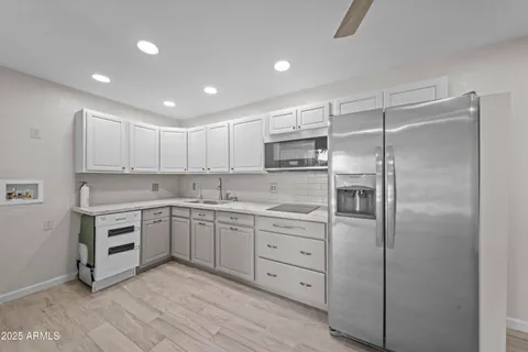 a kitchen with white cabinets and stainless steel appliances
