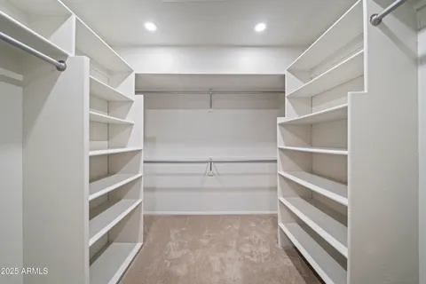 a view of walk in closet with empty racks
