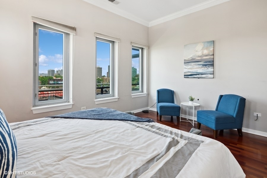3920 North Sheridan Road, Unit 504 Chicago, IL 60613 - Photo 13 of 21 a bedroom with a bed and a chair with window