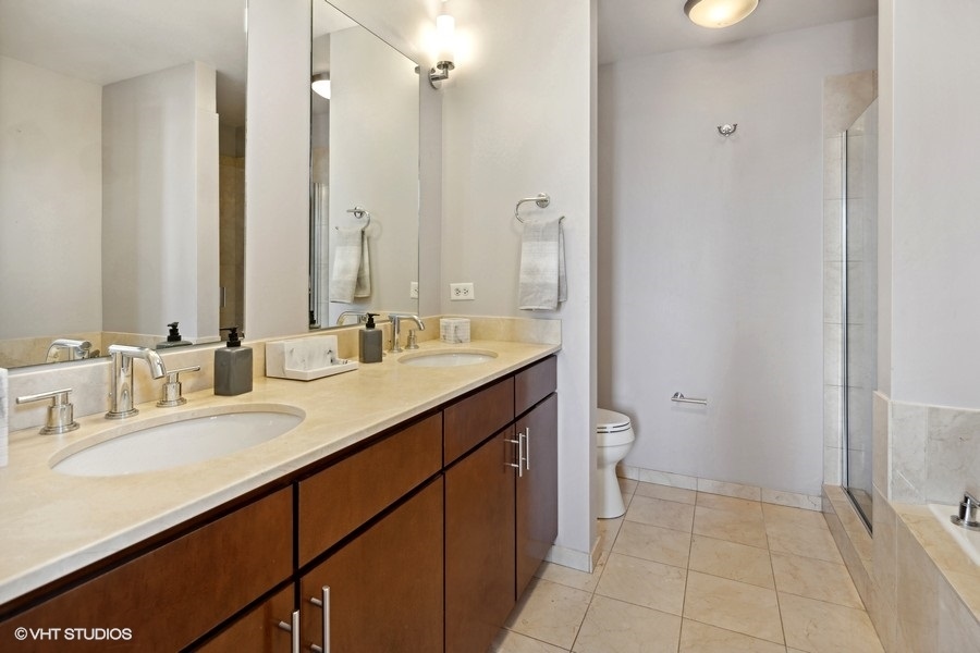 3920 North Sheridan Road, Unit 504 Chicago, IL 60613 - Photo 14 of 21 a bathroom with a granite countertop sink a toilet and a mirror