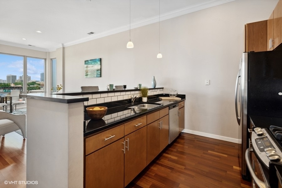 3920 North Sheridan Road, Unit 504 Chicago, IL 60613 - Photo 10 of 21 a kitchen with stainless steel appliances granite countertop a sink stove and refrigerator