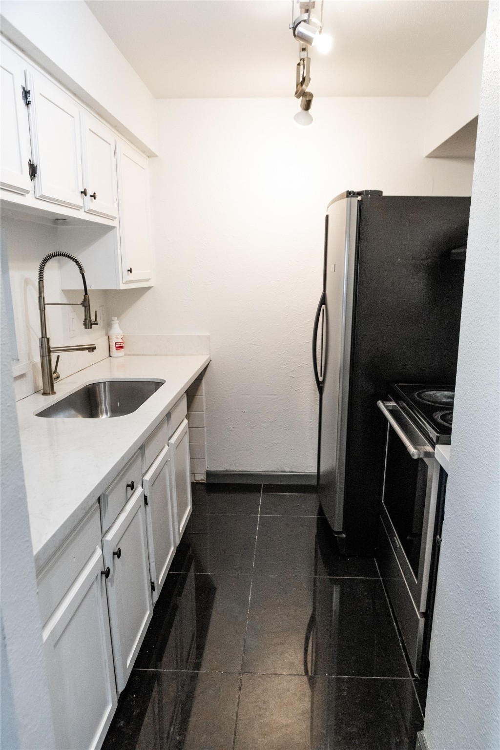 a kitchen with refrigerator and cabinets