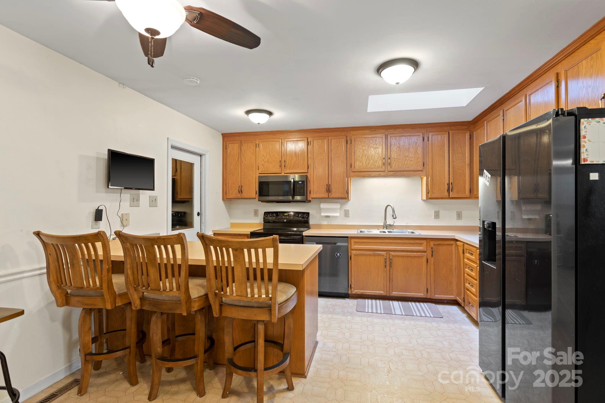 207 Mint Way Flat Rock, NC 28731 - Photo 11 of 27 a kitchen with stainless steel appliances granite countertop a refrigerator a stove a sink a dining table and chairs with wooden floor