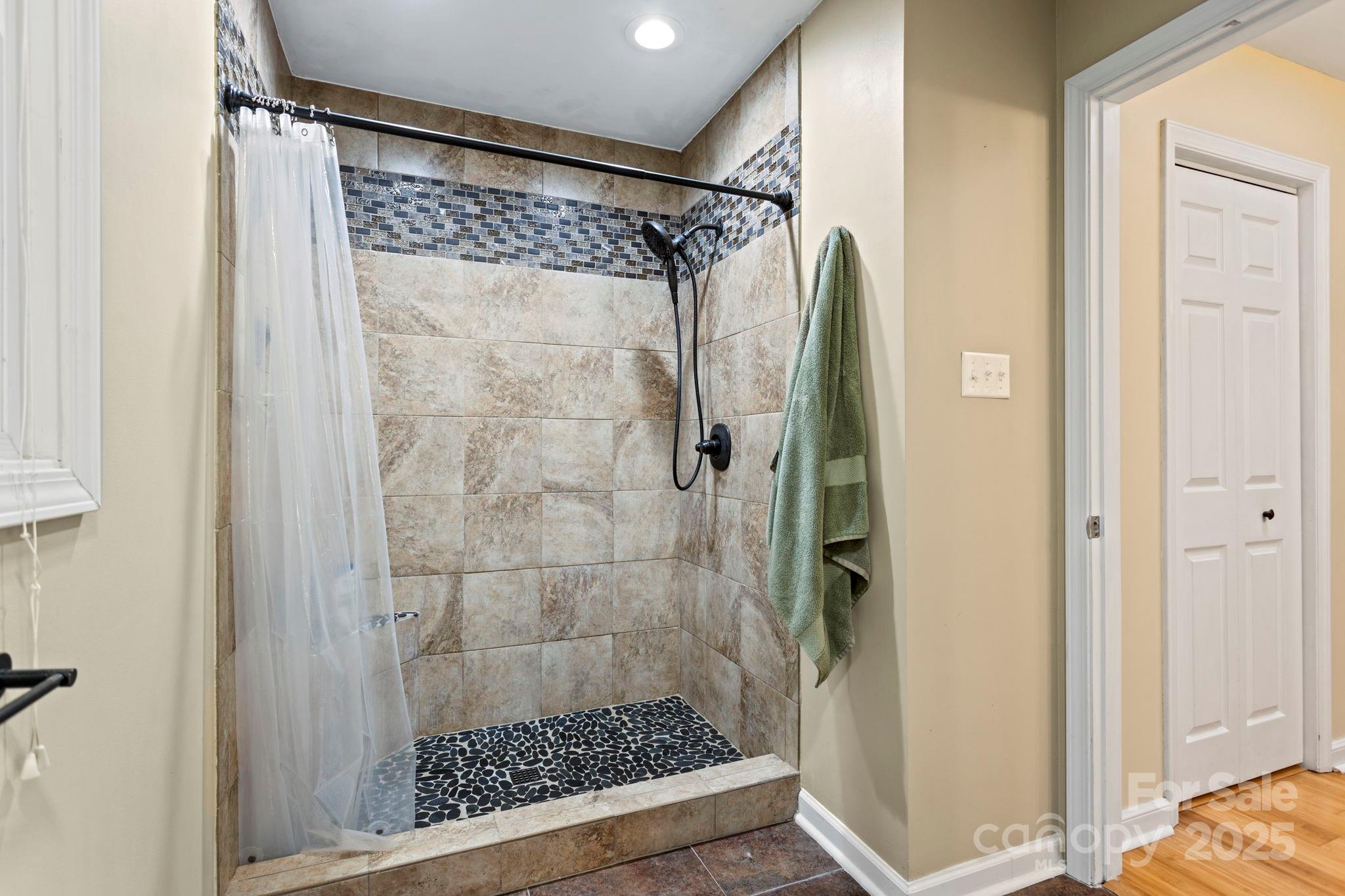 207 Mint Way Flat Rock, NC 28731 - Photo 17 of 27 a bathroom with a glass shower door