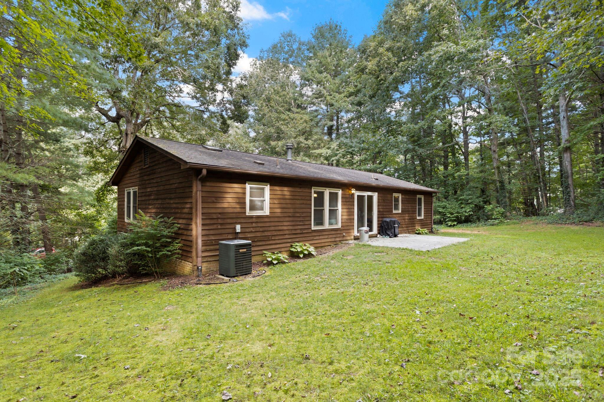 207 Mint Way Flat Rock, NC 28731 - Photo 22 of 27 a front view of house with yard and trees in the background
