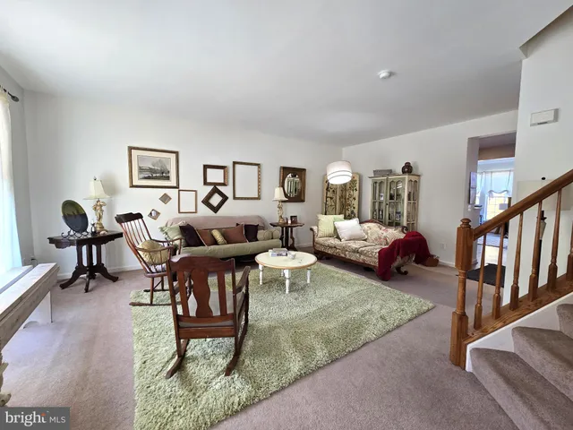 a living room with furniture a rug and a window