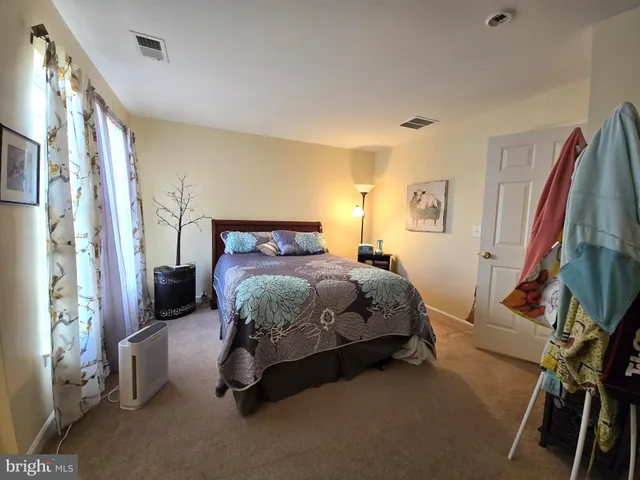 a bedroom with a bed and a flat tv screen on dresser