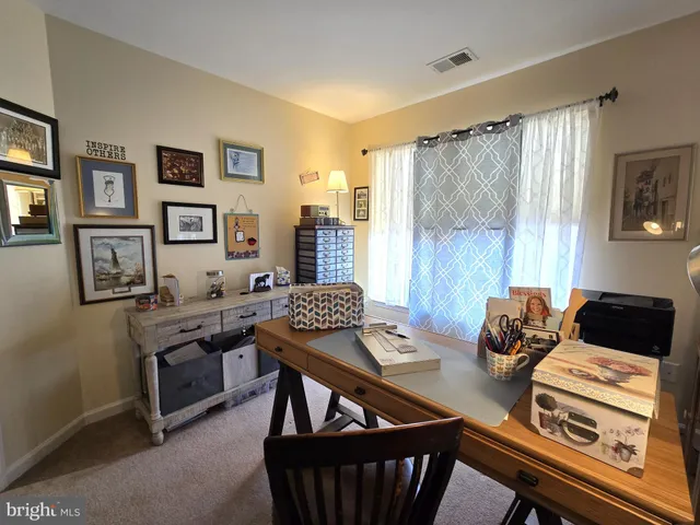 a view of a workspace with furniture and a window