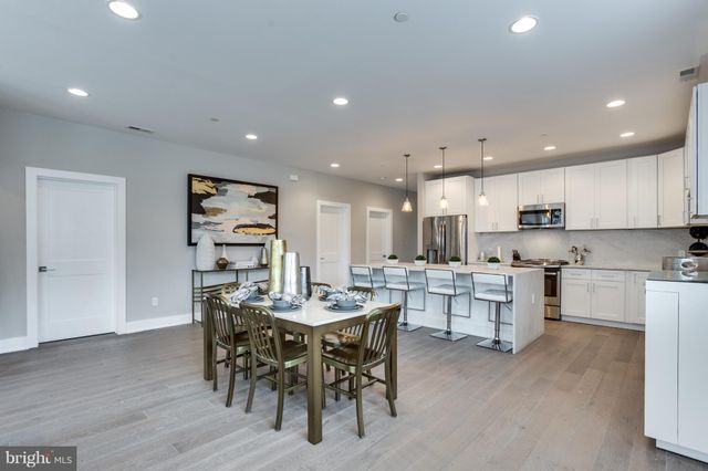 a large kitchen with a table and chairs