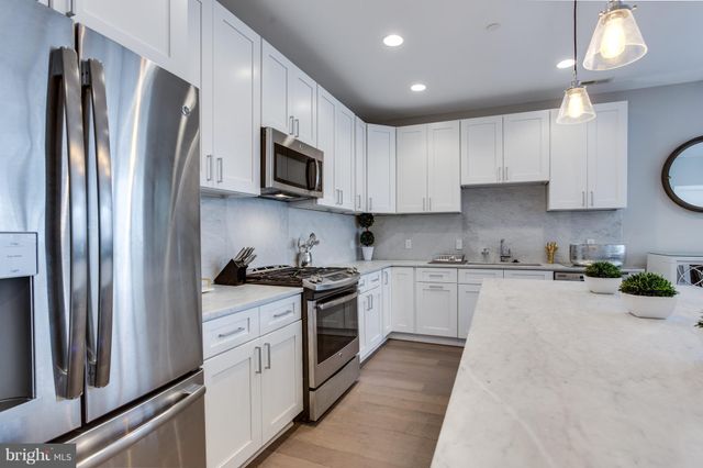 a kitchen with stainless steel appliances granite countertop a refrigerator sink and stove