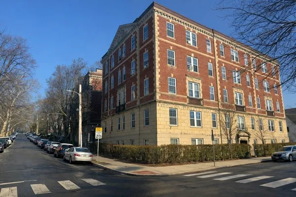 a view of a building and car parked on the side of road