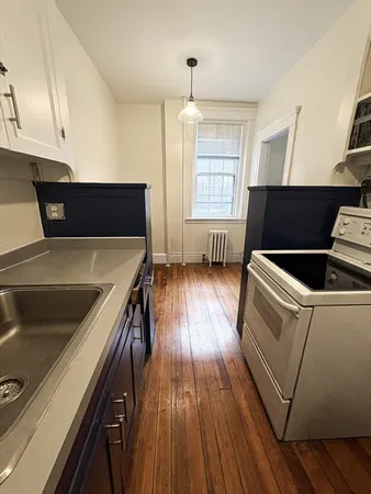 a view of a kitchen with wooden floor and electronic appliances