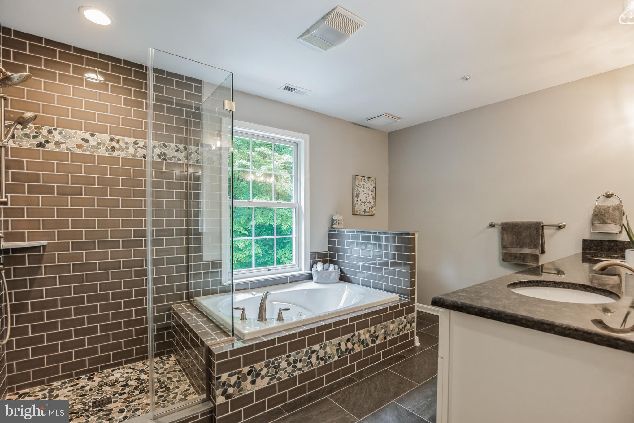 680 Small Reward Road Huntingtown, MD 20639 - Photo 13 of 40 a bathroom with a granite countertop sink a bathtub a mirror a vanity and a shower