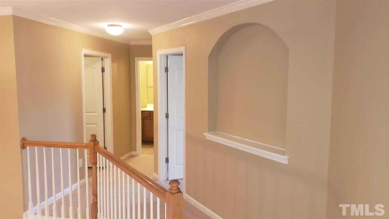 9708 Renfield Drive Raleigh, NC 27617 - Photo 12 of 24 a view of a hallway with wooden floor and staircase