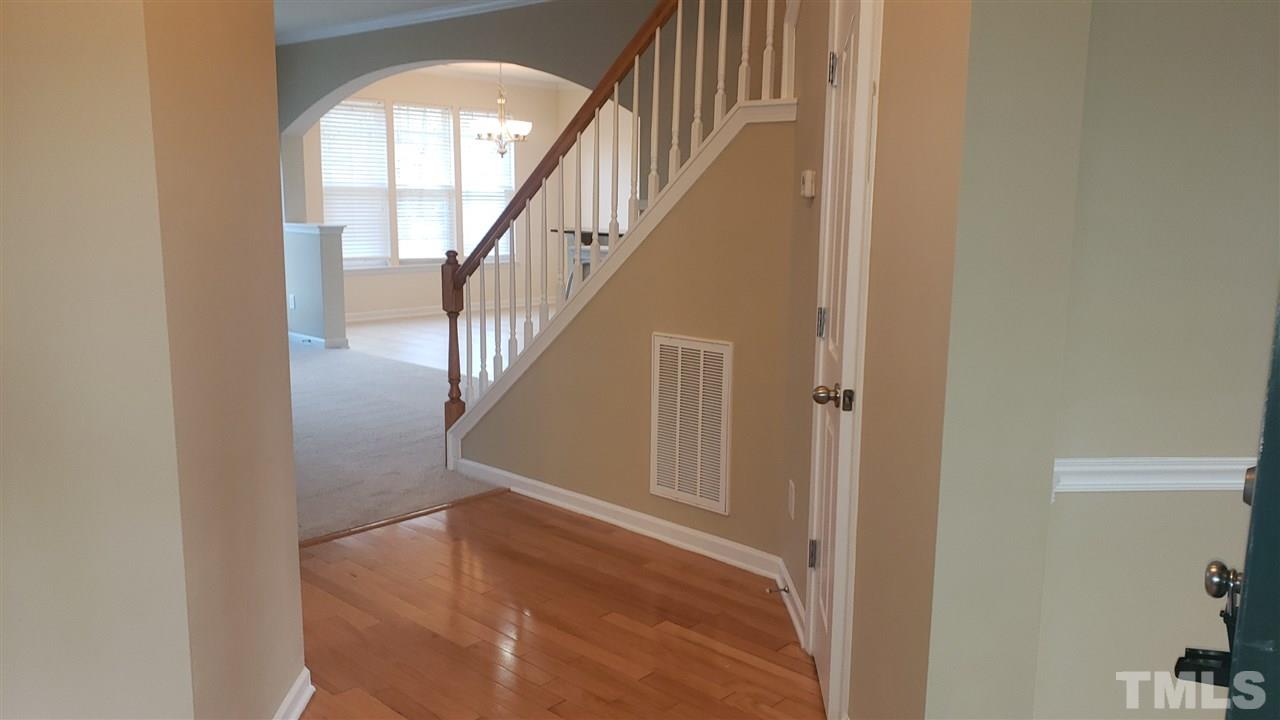 9708 Renfield Drive Raleigh, NC 27617 - Photo 3 of 24 a view of staircase with wooden floor and a large window