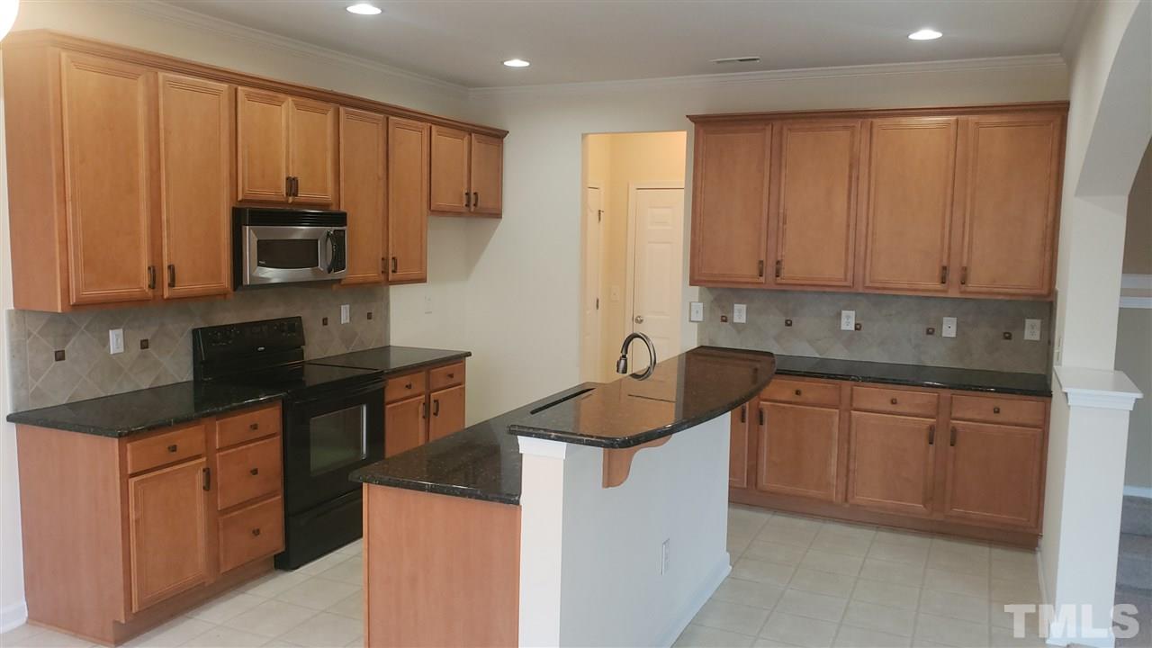 9708 Renfield Drive Raleigh, NC 27617 - Photo 8 of 24 a kitchen with stainless steel appliances granite countertop a sink stove and microwave