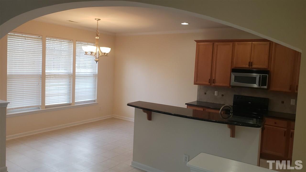 9708 Renfield Drive Raleigh, NC 27617 - Photo 9 of 24 a kitchen with stainless steel appliances a sink a stove a microwave and cabinets