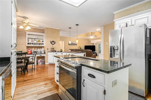 a kitchen with stainless steel appliances granite countertop a stove refrigerator and cabinets