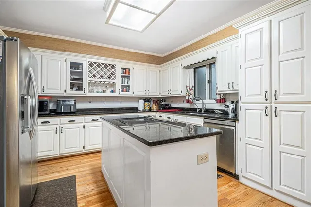 a kitchen with stainless steel appliances granite countertop a stove a sink and a refrigerator