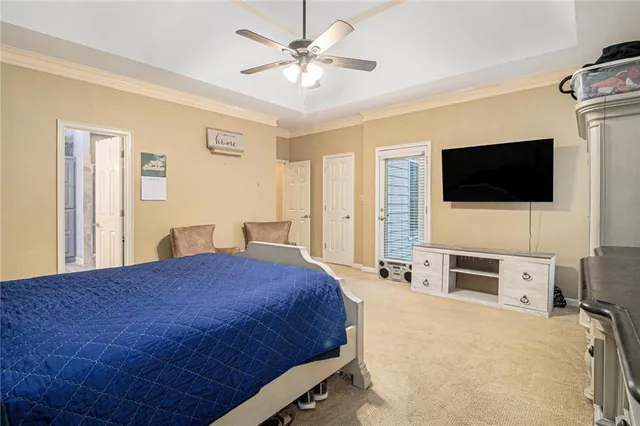 a bedroom with a bed a flat screen tv and dresser