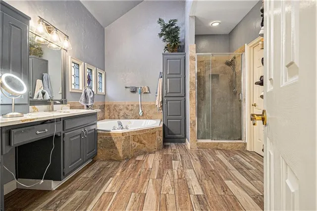 a spacious bathroom with a tub sink shower and a mirror
