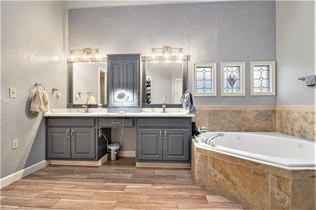 a bathroom with a tub sink and mirror