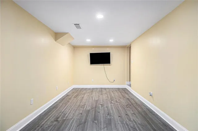 a view of a room with wooden floor and white walls