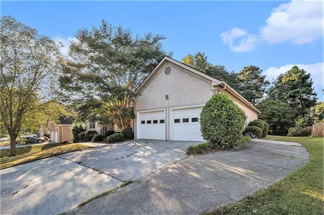 a view of a house with a yard and potted plants