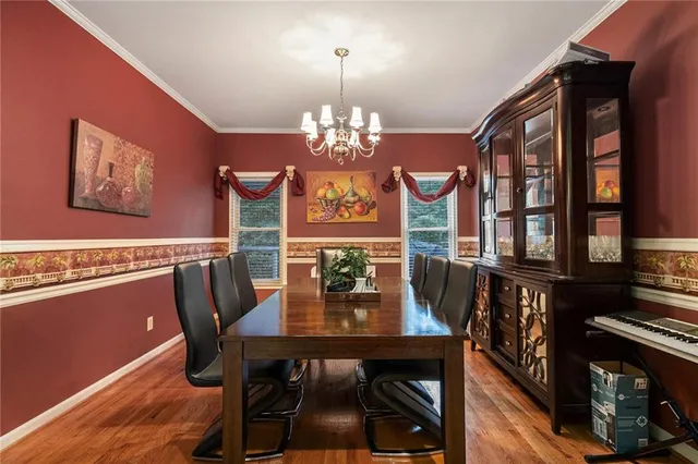 a view of a dining room with furniture a chandelier and wooden floor