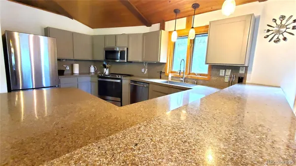 a kitchen with stainless steel appliances granite countertop a sink refrigerator stove and microwave