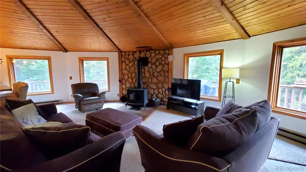 a living room with furniture a flat screen tv and large window