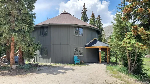 a view of a house with a yard and tree