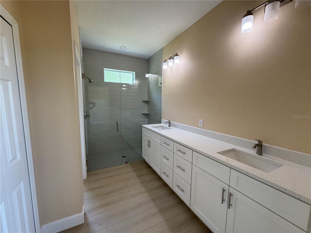 4661 Hickory Tree Road St. Cloud, FL 34772 - Photo 15 of 20 a bathroom with double vanity sink a mirror and a shower