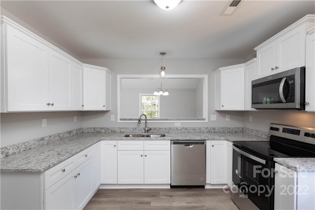 6184 Hopewell Road Hickory Grove, SC 29717 - Photo 21 of 30 a kitchen with granite countertop a sink a stove and microwave
