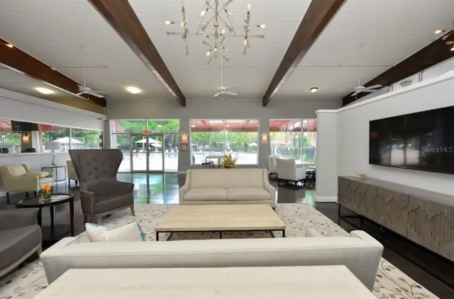 a living room with furniture a flat screen tv and kitchen view