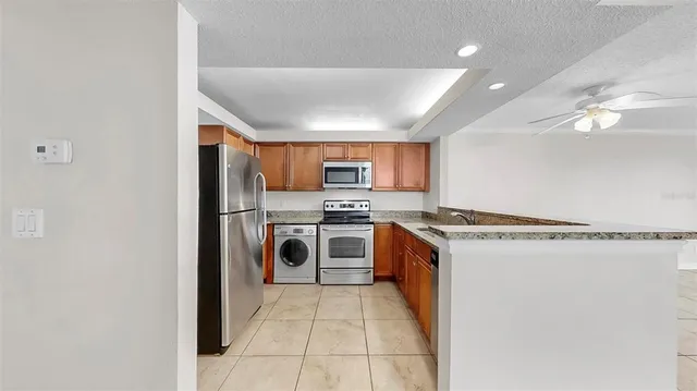 a kitchen with stainless steel appliances granite countertop a refrigerator and a stove top oven