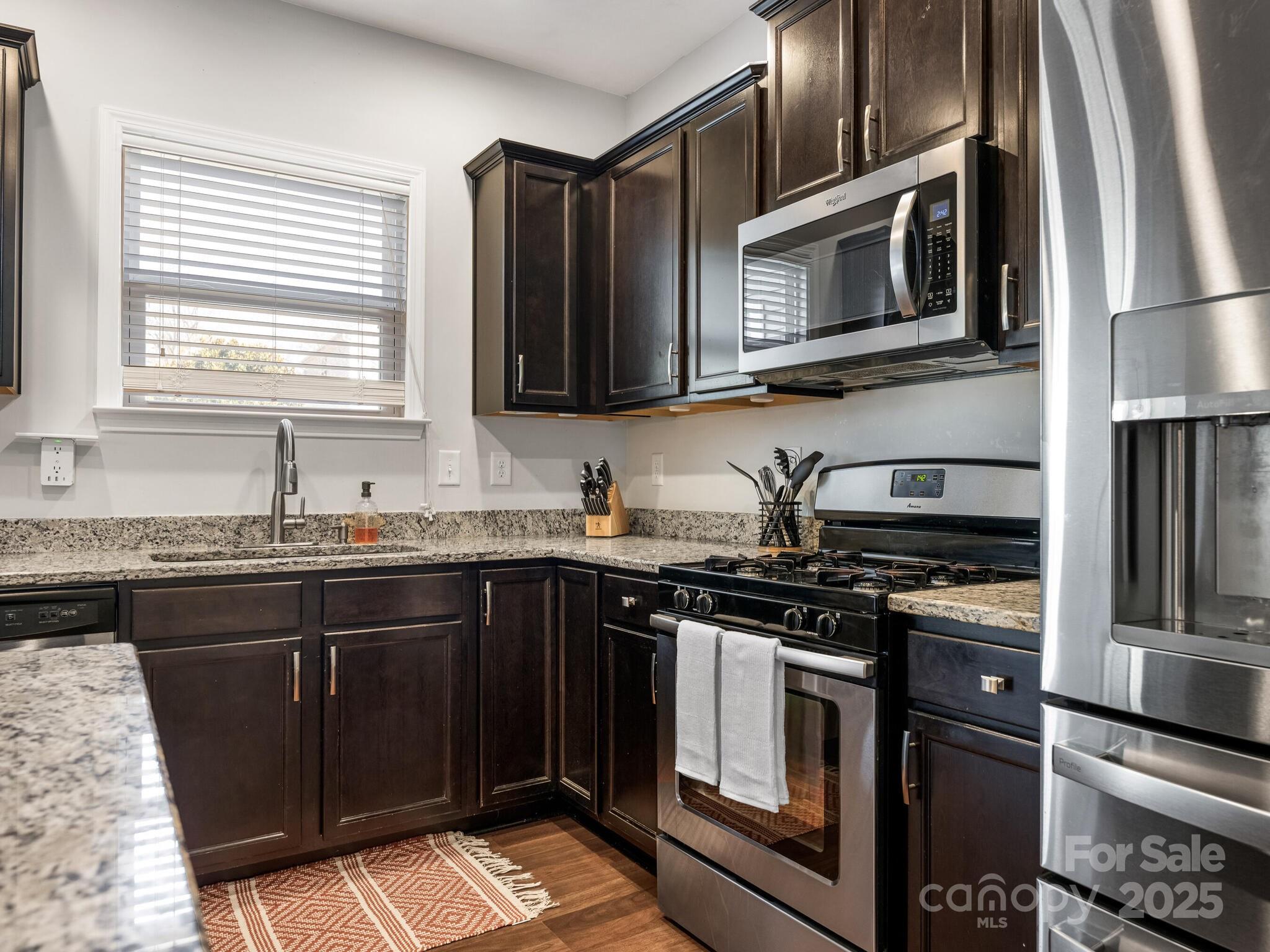 13118 Great Laurel Road Charlotte, NC 28227 - Photo 11 of 38 a kitchen with stainless steel appliances granite countertop a stove microwave and sink