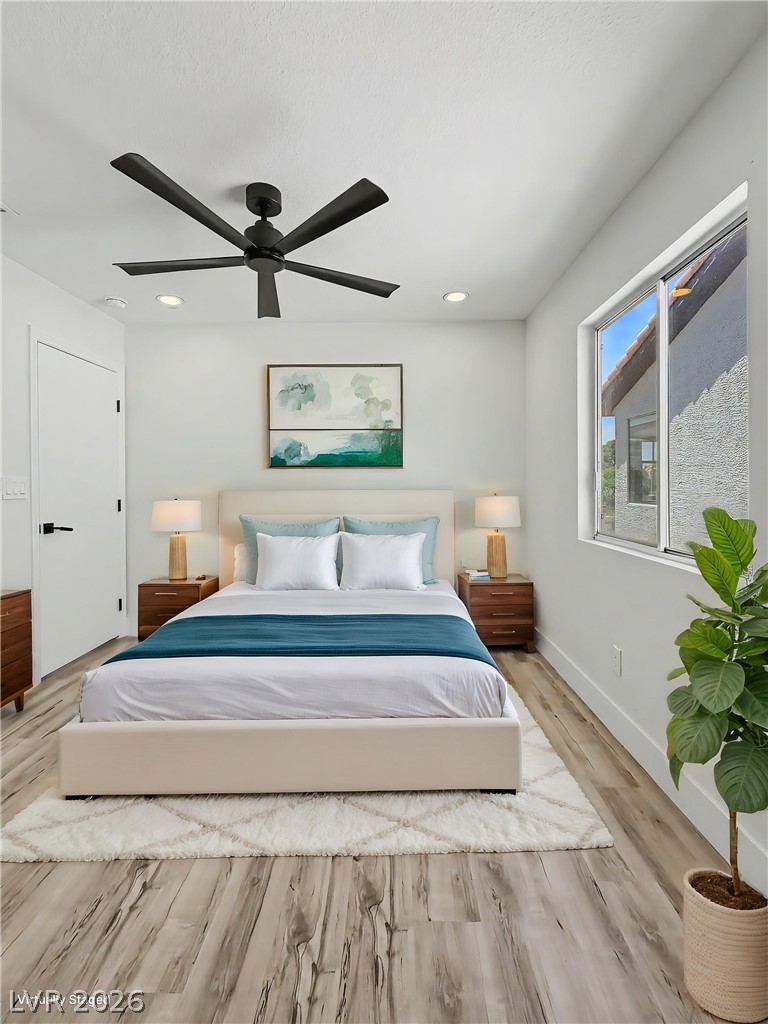 8977 Paige Rene Court Las Vegas, NV 89117 - Photo 20 of 31 A well-lit bedroom features durable hardwood flooring and a stylish black ceiling fan.