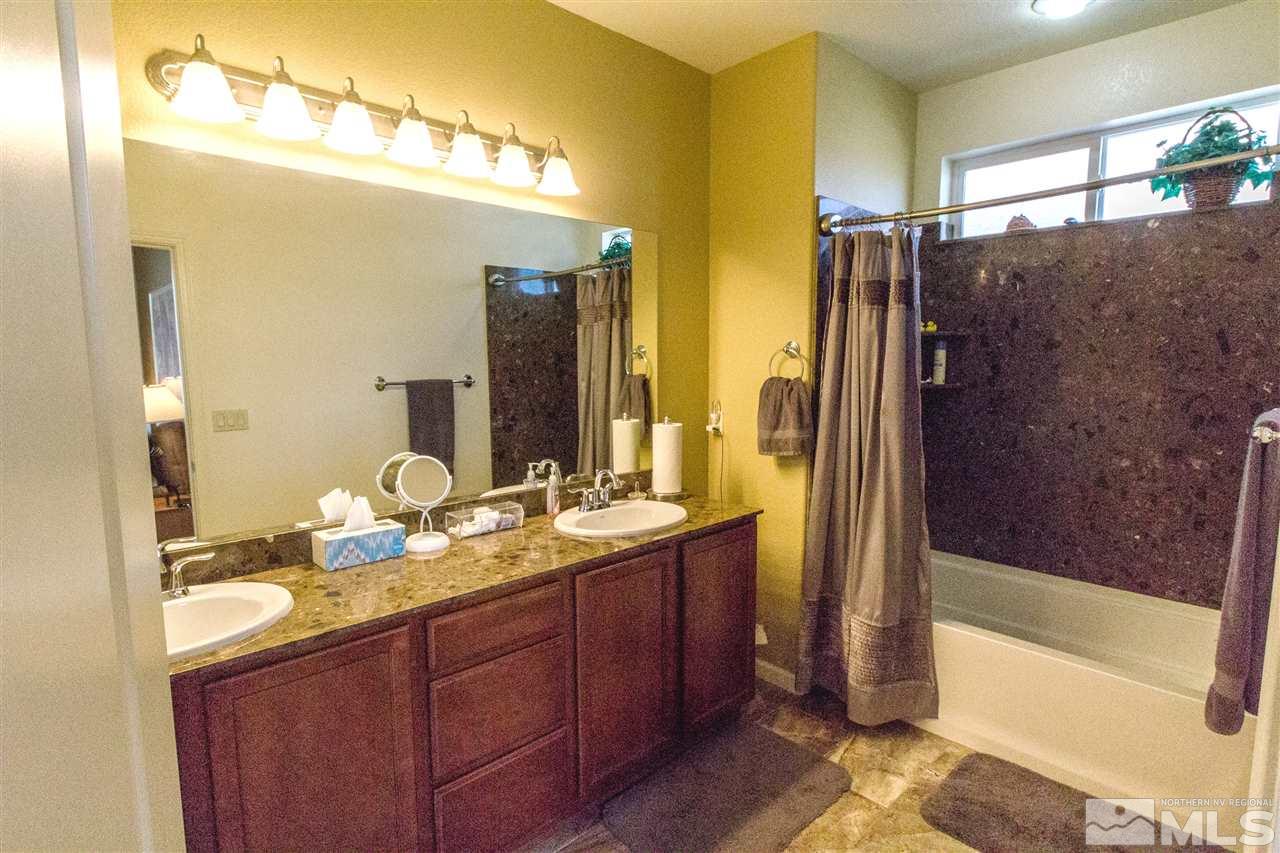 2285 Makenna Drive Reno, NV 89521 - Photo 13 of 24 a bathroom with a granite countertop sink mirror and a bathtub